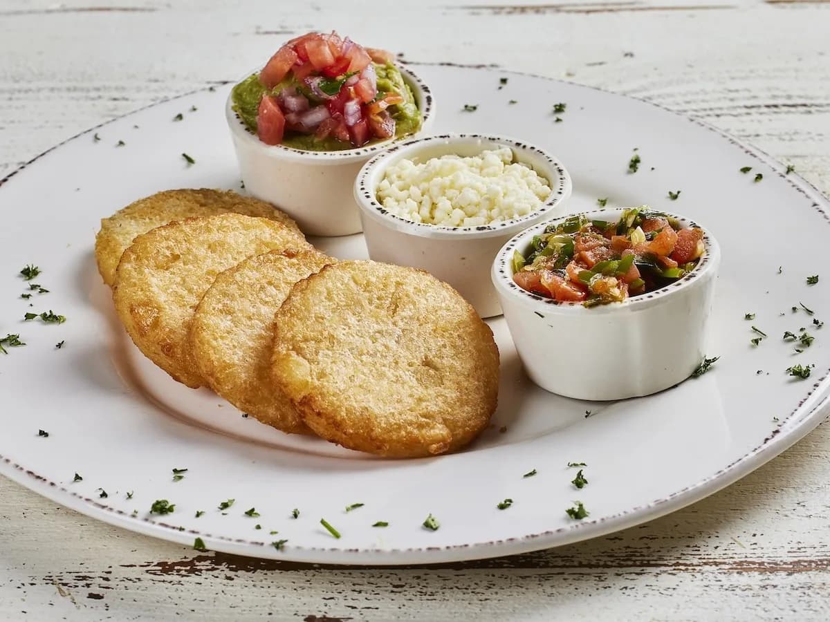 A serving of Arepitas de yuca con guacamole, hogao y queso